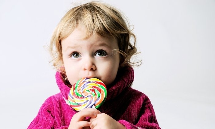 Mergaitė su saldainiais ant pagaliuko