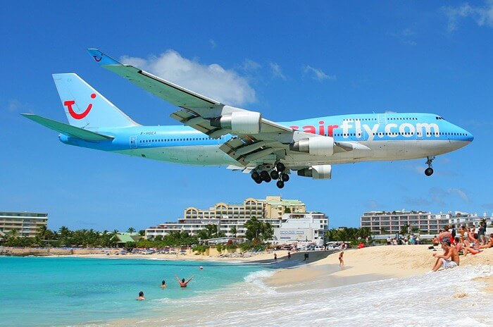 Het vliegtuig landt over het strand