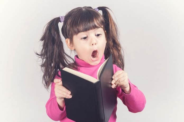 La bambina reagisce durante la lettura di un libro